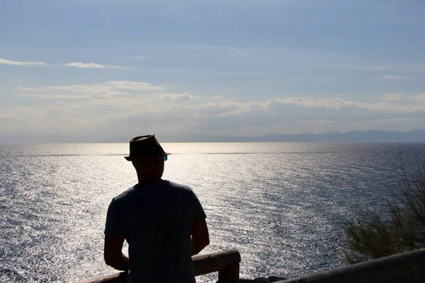 silhoutte of a man with hat while looking at the sea