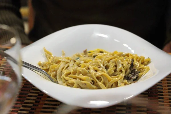 Beyaz seramik kasede porcini mantarlı makarna tagliatelle.