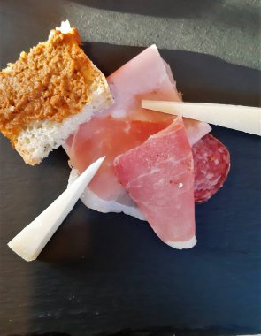 Lezzetli bir tabak sosis, İtalyan peyniri ve bruschetta.