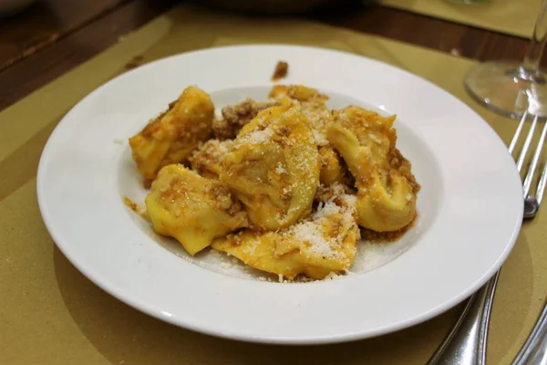 Bir tabak kabaklı tortelli et soslu ve restoranda parmesan soslu, tipik İtalyan yemeği.