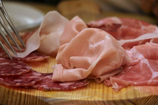 Lezzetli bir tabak soğuk et, mortadella, jambon, pişirilmiş et, ahşap tepside salam İtalyan yemeği.