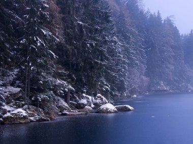 Foggy and misty morning hike around an Austrian Alps frozen lake