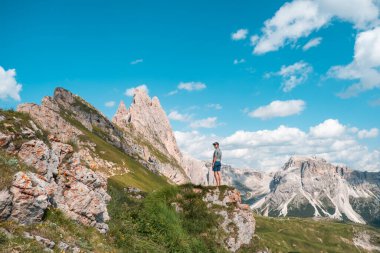 Woman rest on fields around mountains after a hike