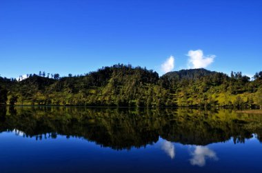 Ranu Kumbolo Gölü 'nün etrafındaki tepelerin yansıması..