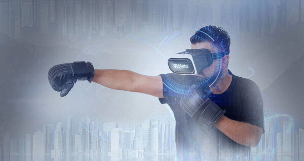 Guy Wearing Virtual Reality Goggles Playing Boxing Sports Inside A Metaverse - Meta Written On The Googles