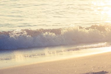 Sunlit Waves Crashing onto The Beach at Daybreak