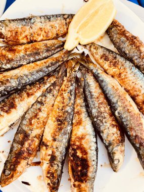 Limonlu ızgara uskumru balığı ve beyaz ahşap arka planda baharatlar..