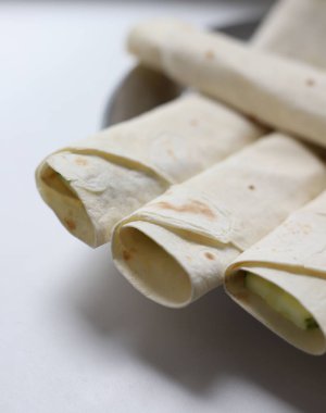 Lavaş rulosu, kırmızı somon dolması ve erimiş peynirle tatlandırılmış yeşil sulu salatalık içine dilimlenmiş. mağaza afişleri ve yemek kitabı kapakları için