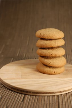 Açık kahverengi çatallı birkaç tatlı yuvarlak kurabiye yakındaki ahşap bir mutfak tezgahının üzerinde duruyor. Yıldız anason 'un birkaç parçasına baharat katılıyor. Yemek tarifi kitaplarının afişleri için.
