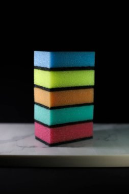 İlan afişleri için siyah arkaplanda farklı renkte mutfak süngerleri