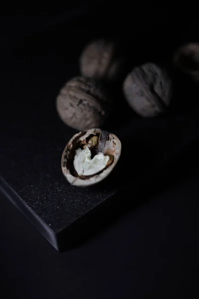 cut walnut tart on a black kitchen cutting board on a black background.for cookbooks with recipes banners labels for different types of products