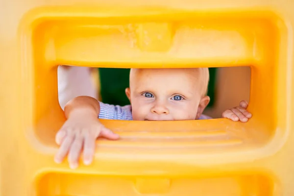 Small boy peers through a narrow plastic hole. Portrait. High quality photo
