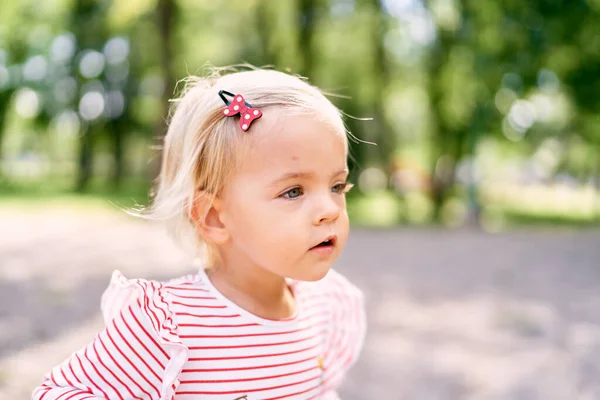 Little girl with a hairpin in red polka dots. Profile. High quality photo