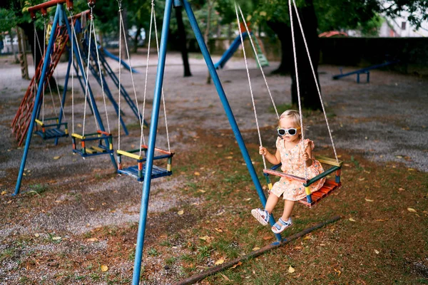 Menina Óculos Sol Balança Num Baloiço Corda Parque Infantil Foto — Fotografia de Stock