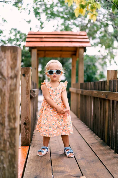 Niña Con Gafas Sol Posando Puente Madera Patio Foto Alta — Foto de Stock