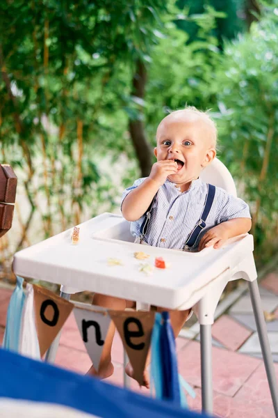 笑着的小男孩坐在高椅子上吃饭 高质量的照片 — 图库照片