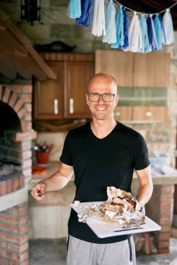 Gülümseyen adam elinde bir tepsi etle fırının yanında duruyor. Yüksek kalite fotoğraf