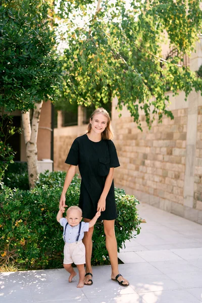 Mamma Håller Liten Pojke Händerna När Hon Står Nära Stenmur — Stockfoto