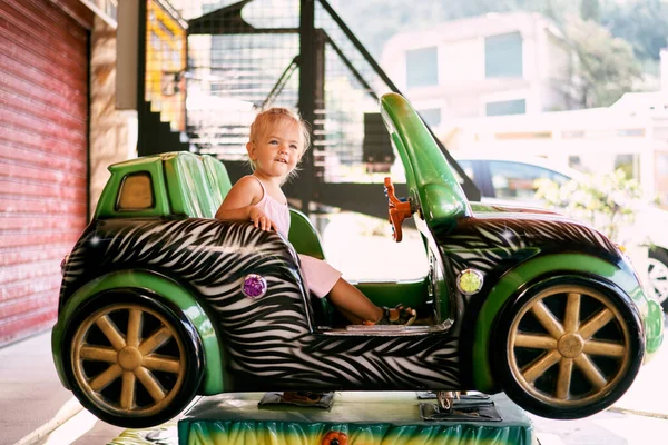 Küçük kız salıncak dengeleyicisinde oturuyor. Yüksek kalite fotoğraf