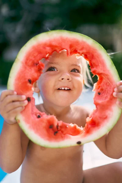 Ein Kleines Mädchen Guckt Durch Ein Loch Einem Stück Wassermelone — Stockfoto