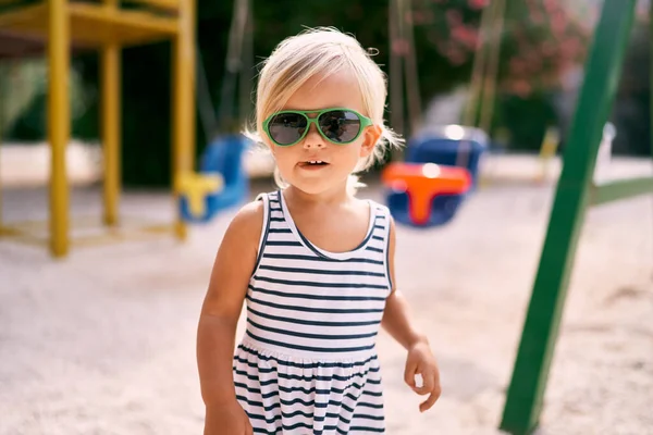 Çocuk parkında güneş gözlüklü bronzlaşmış küçük kız. Portre. Yüksek kalite fotoğraf