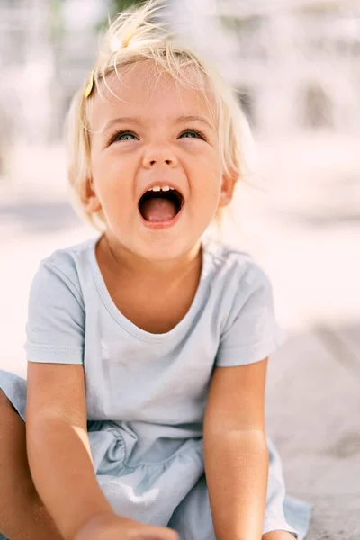 Küçük kız ağzı açık ve başı dik güler. Portre. Yüksek kalite fotoğraf