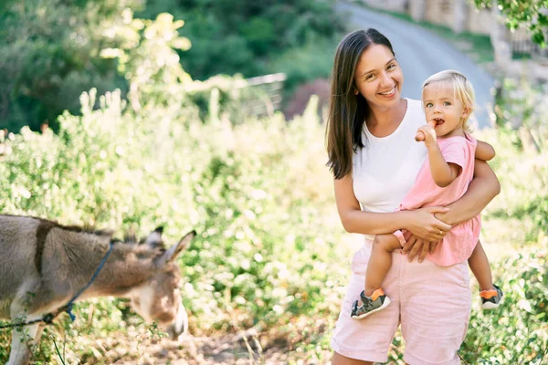 Leende Mamma Med Liten Flicka Som Tuggar Morot Står Hage — Stockfoto