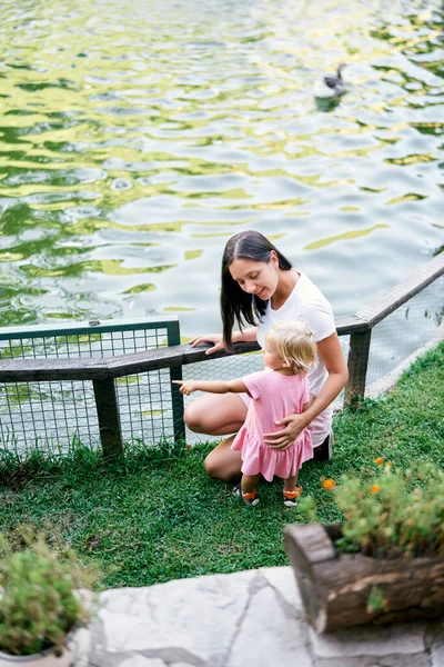 Mamma Med Liten Flicka Sitter Stranden Sjön Nära Staketet Högkvalitativt — Stockfoto