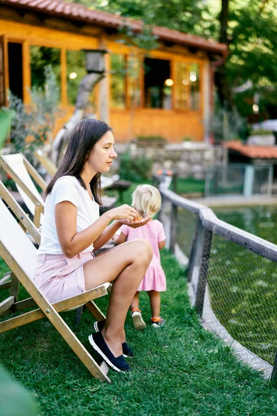 Mamma Med Morötter Handflatan Sitter Hopfällbar Stol Nära Ett Trähus — Stockfoto