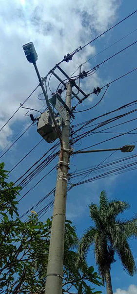 Electric cables and poles together with a beautiful blue sky
