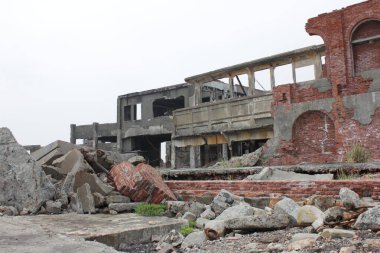 Battleship Island destroyed buildings. Red bricks building with concrete rocks. Nagasaki coal mining old buildings.