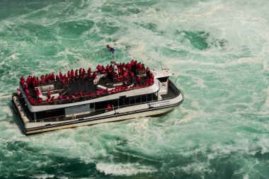 NIAGARA FALLS, ONTARIO, CANADA - 9 / 2021 AĞUSTOS - Niagara Şelalesi 'nde Niagara City Cruises' in sahibi olduğu Niagara Wonder yolcu gemisiyle gezintiye çıkan turistler. 