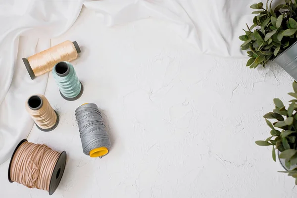 Top view of colorful threads on a bright table.