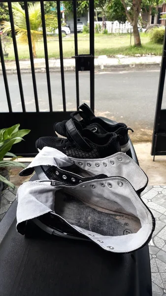 Black shoes drying in front of the house
