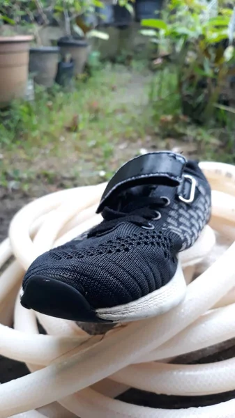 Black shoes drying in front of the house