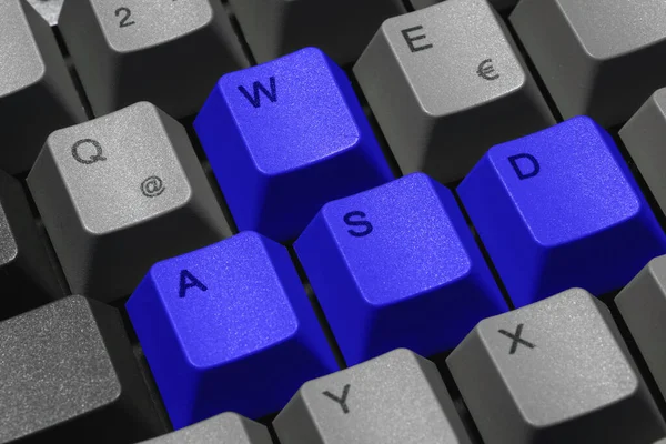 Closeup of keys on a gaming keyboard with the WASD keys highlighted in blue