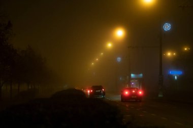 Şehirde sis var. Sisli şehir ışıkları. yol..