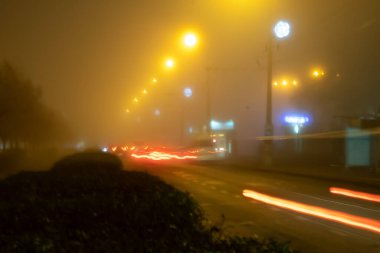 Şehirde sis var. Sisli şehir ışıkları. yol..