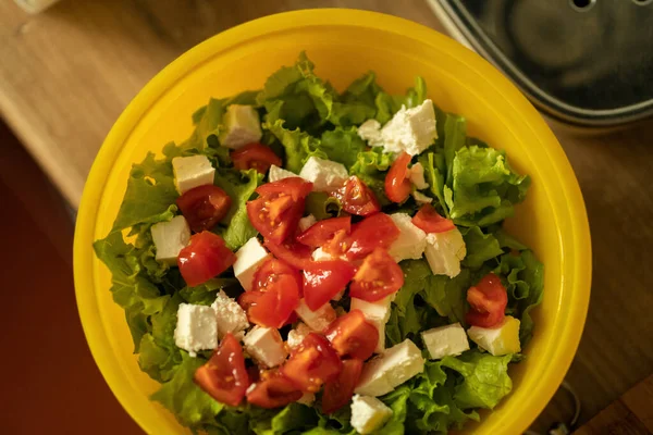 homemade light salad of lettuce, tomatoes, feta cheese and canned salmon. home cooking.