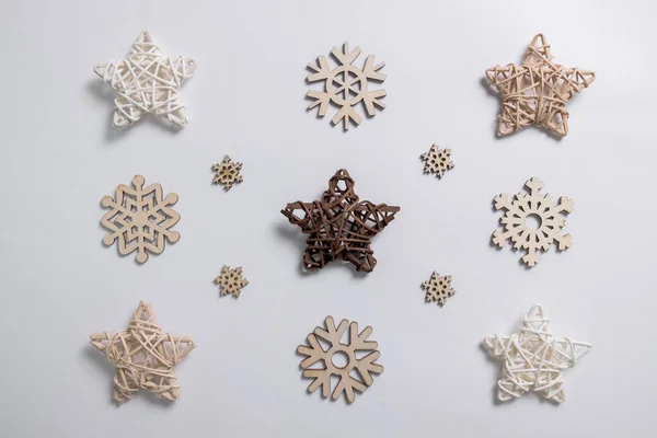 Christmas winter festive ornament. Christmas snowflakes decoration and wooden stars on white background. Christmas holiday decoration. Minimal holiday greeting season. Flat lay, top view.