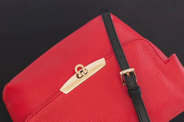 Bolso de mano rojo pequeño de cuero genuino, detalles dorados sobre fondo negro. Compras, fabricación, estilo de vida — Foto de Stock