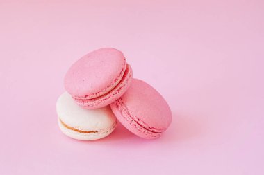 Üç yumuşak renkte badem kurabiyesi, tatlı Fransız yemeği, pastel arka plan..