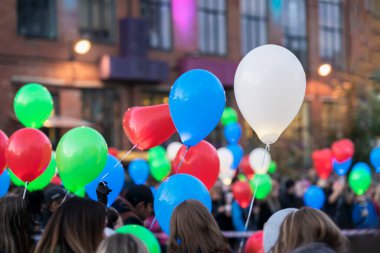 Bir sürü renkli balon, şehirdeki bir sürü insanın elinde. Tatil kavramı