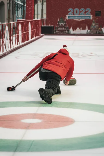 Curling training. Player plays curling on the ice rink, directing stone on target — Stock Photo, Image