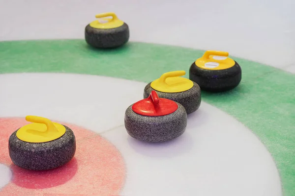 Curling stones on playing field on ice rink