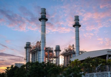 Günbatımında gökyüzü olan petrol sanayi tesislerinin boru hattı ve boru hattı.
