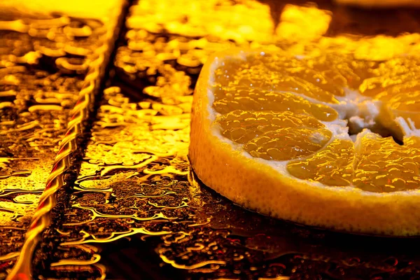 orange slice. close up of orange fruits on table. orange slice for cocktail. cocktail mixer spoon. orange with water drops. neon yellow lighting for fruit.