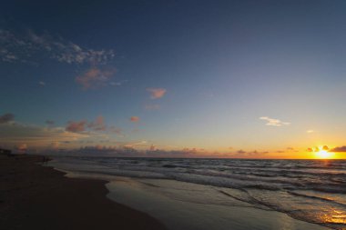 Denizin üzerinde gün batımı.