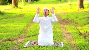 A middle-aged Asian Muslim man prays at his home during the month of Ramadan