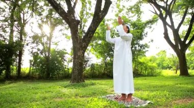 Muslim man praying to god or performing salah, namaz or prayer - concept of spirituality, religious faith or belief on Allah